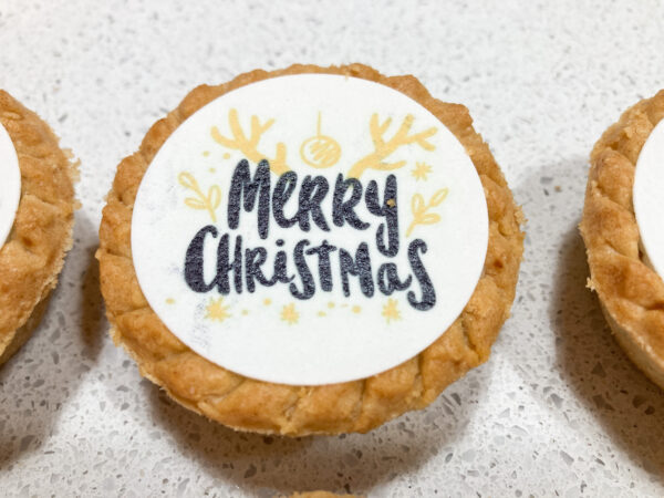 Mince pie decorated with printed image topper saying Merry Christmas